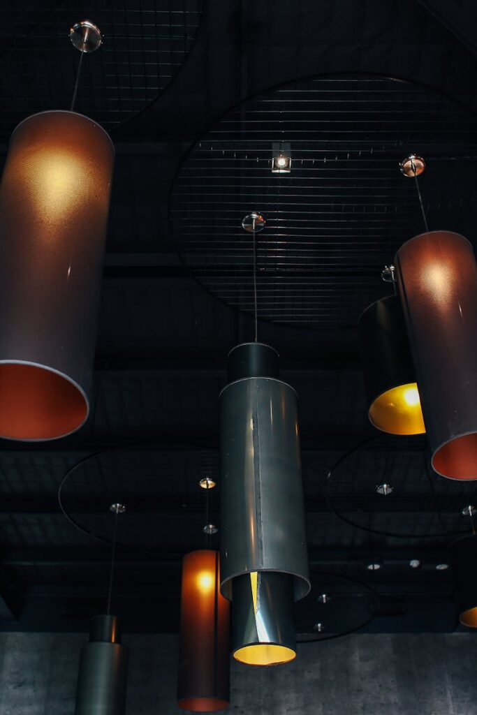 A low angle shot showcasing industrial style pendant lights against a dark ceiling, creating a moody atmosphere.